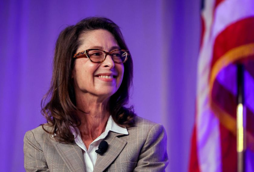 woman in professional clothes and glasses smiling